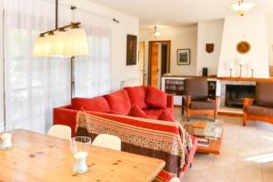 un soggiorno con divano rosso e tavolo di Casa gabriela a Calonge