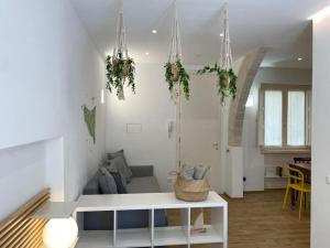 a white living room with plants hanging from the ceilings at Casa Maier in Trapani