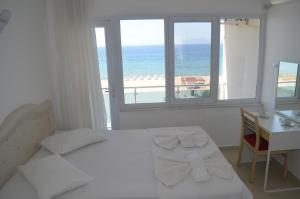 a bedroom with a bed and a desk and a window at Yasmin Hotel in Ayvalık