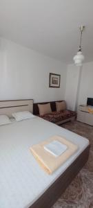 a bedroom with a white bed and a couch at Casa Branca in Sozopol