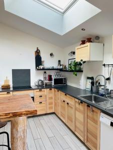 a kitchen with wooden cabinets and a black counter top at la P’tite Grange in La Cotinière