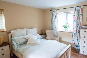 a bedroom with a white bed and a window at The Talbot Arms in Lyme Regis