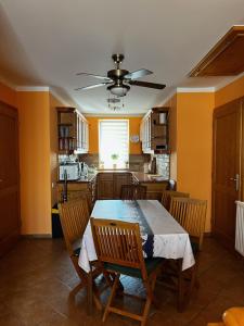 a dining room with a table and chairs and a kitchen at Sunset Beach Apartmanház in Balatonvilágos