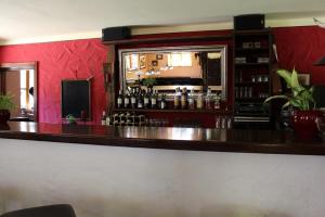 a bar in a restaurant with a red wall at GENSLEITEN in Reut