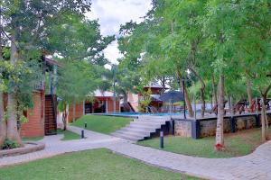 un parque con piscina, árboles y un edificio en Tepraas Sigiriya en Sigiriya