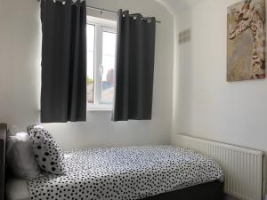 a bed in a room with black curtains and a window at Immaculate 3-Bed House in Nottingham in Nottingham