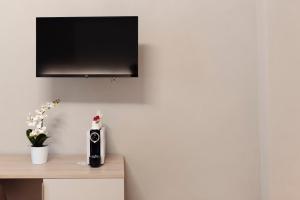 um quarto com uma televisão numa parede com uma secretária em Gli Appartamentini del Bistrot dei Vinai em Cuneo