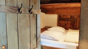 1 dormitorio con 1 cama en una cabaña de madera en De Schaapskooi en Hezingen