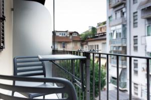 Gli Appartamentini del Bistrot dei Vinai في كونيو: شرفة مع طاولة وكراسي على شرفة