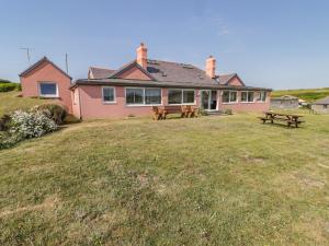 a pink house with picnic tables in front of it at St Justinians in St. Davids