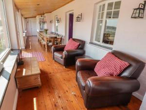 a living room with two leather chairs and a table at St Justinians in St. Davids