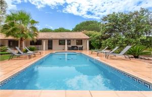 a swimming pool with chairs and a house at Lovely Home In Vias With Outdoor Swimming Pool in Vias