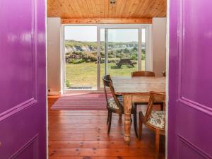 a dining room with a table and chairs and a window at St Justinians in St. Davids
