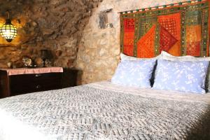 um quarto com uma cama com um cobertor e almofadas em Traditional stone build private studio em Verga Kalamata