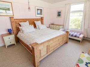 a bedroom with a large wooden bed and a window at St Justinians in St. Davids