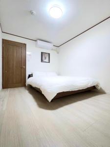 a bedroom with a bed and a wooden door at guesthouse Nakatsu in Osaka