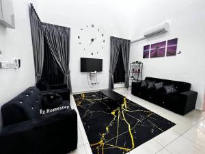 a living room with two black couches and a tv at Rz Homestay in Melaka