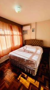 a bedroom with a bed in a room with a window at Ótima localização quadra mar e central in Balneário Camboriú