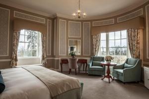 una camera da letto con un letto, due sedie e un tavolo di Leixlip Manor Hotel a Leixlip