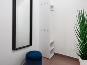 Habitación con silla azul y espejo. en SKY9 Apartments Stadthalle, en Viena