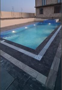 una piscina de agua azul en un edificio en Villa Novxani, en Baku