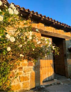 un edificio de ladrillo con una puerta de madera. en Alojamientos La Ermita, en Navamuel