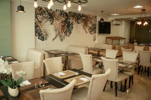 a restaurant with wooden tables and white chairs at Hôtel Belle Vue et Spa in Meknès