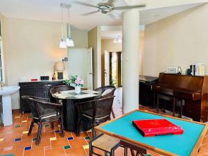 een woonkamer met een tafel en een piano bij Batu Pahat Santalia Pool Villa 4BR 1k4Q 12~16px in Batu Pahat