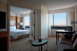 Cette chambre comprend un lit, un bureau et une télévision. dans l'établissement Washington Dulles Marriott Suites, à Herndon