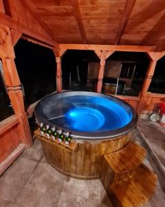 a hot tub in a wooden room with bottles of beer at Casa OLD BRICK in Ocna Şugatag