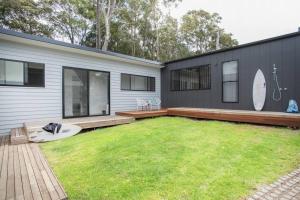 a backyard of a house with a large yard at Bawley Beach House, Short Walk to Bawley Beach in Bawley Point