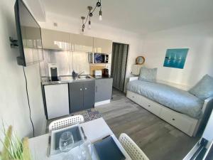 pequeña sala de estar con sofá y cocina en Bleu Azur, en Juan-les-Pins