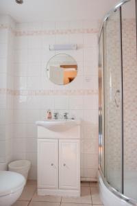 a white bathroom with a sink and a shower at The Talbot Arms in Lyme Regis
