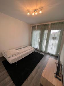1 dormitorio con 1 cama y TV. en Modern Apartman, en Szeged