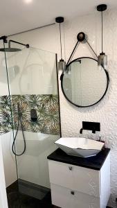 La salle de bains est pourvue d'un lavabo et d'une douche avec un miroir. dans l'établissement Domki pod gwieździstym niebem, à Zastań