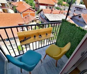 a balcony with two chairs and a table and chairs at MD apartman Vranje FREE PARKING in Vranje