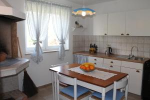 a kitchen with a table with a bowl of fruit on it at Villa Mandolina Apartments in Zadar