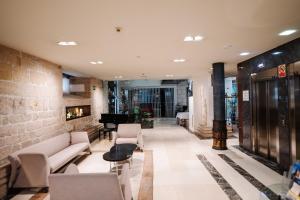 a lobby with couches and a piano in a building at Palacio de los Blasones Suites in Burgos