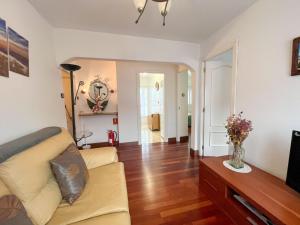 a living room with a couch and a television at APARTAMENTO BERMEOKOSUSTRAIAK-60 m2 wifi gratis in Bermeo