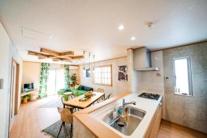 a kitchen with a sink and a living room at SHIOYA STAY in Okinawa City