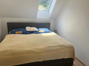 uma cama num pequeno quarto com uma janela em R&H Ubytování u Českého Krumlova - Milenecký azyl - Penzion - Apartmán em Chvalšiny
