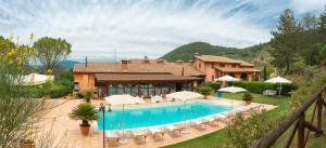 a villa with a swimming pool in front of a house at Hotel Ristorante La Fattoria in Spoleto