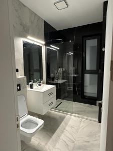 a bathroom with a toilet and a sink and a shower at Koya Tower by Lake Mamaia in Mamaia +19 photos