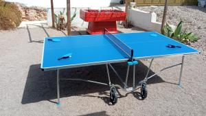 una mesa de ping pong azul con dos delfines. en Villa Paradise , playa climatizada y privada a 10 minutos de Sitges, en Sant Pere de Ribes