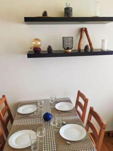 a table with plates and wine glasses on it at Cosy studio Hameau, 2 à 5pers, Wifi in Isola