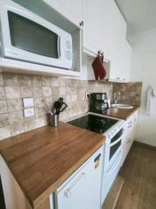 a kitchen with a microwave and a stove top oven at Cosy studio Hameau, 2 à 5pers, Wifi in Isola