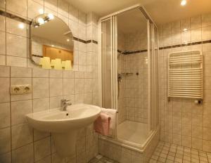ein Bad mit einem Waschbecken und einer Dusche in der Unterkunft Albingers Landhaus in Balderschwang