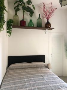 1 dormitorio con 1 cama con jarrones verdes en un estante en Kimy B&b Pompei en Pompei