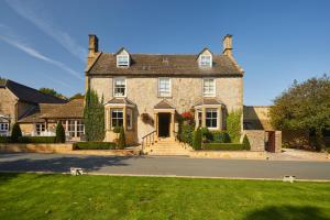een groot bakstenen huis met een oprit ervoor bij Dormy House Hotel in Broadway