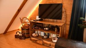 TV en un soporte de madera en la sala de estar en Milošev Konak, en Malo Središte